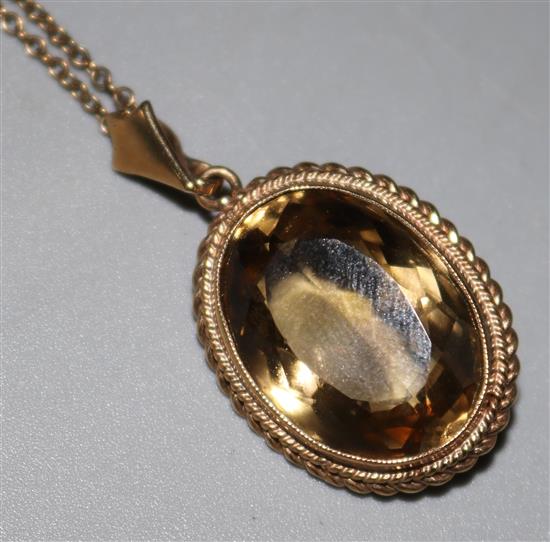 A 9ct gold and oval citrine pendant, on a 9ct gold chain, pendant 1in.
